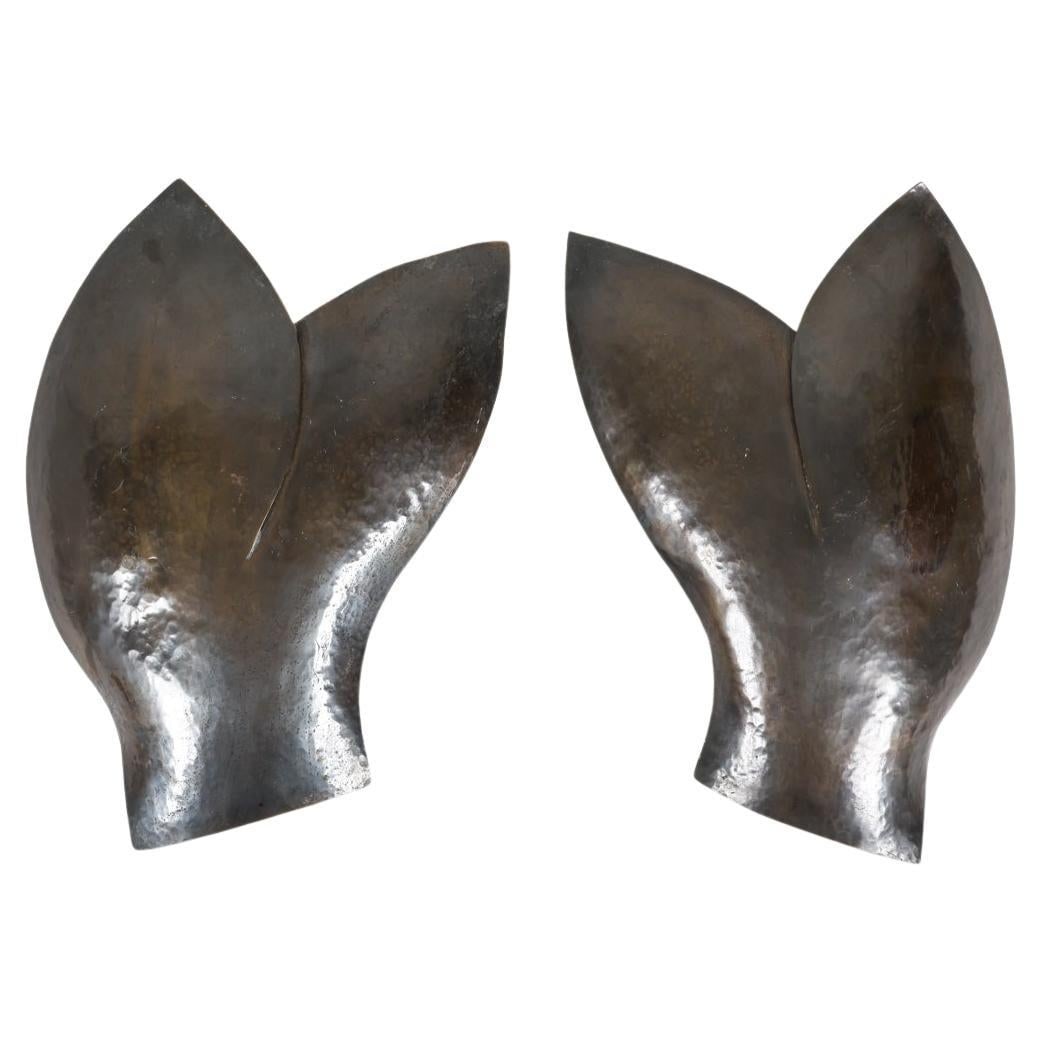 PAIR 'WHALE TAIL' BRONZE SCONCES C. 1970S: Dimensions: H 12.5 in (31.75 cm) x W 9 in (22.86 cm) x D 4.25 in (10.8 cm) Condition; Wear consistent with age and use. Small areas of flaking on inner sides of shades. Minor signs of wear from age an