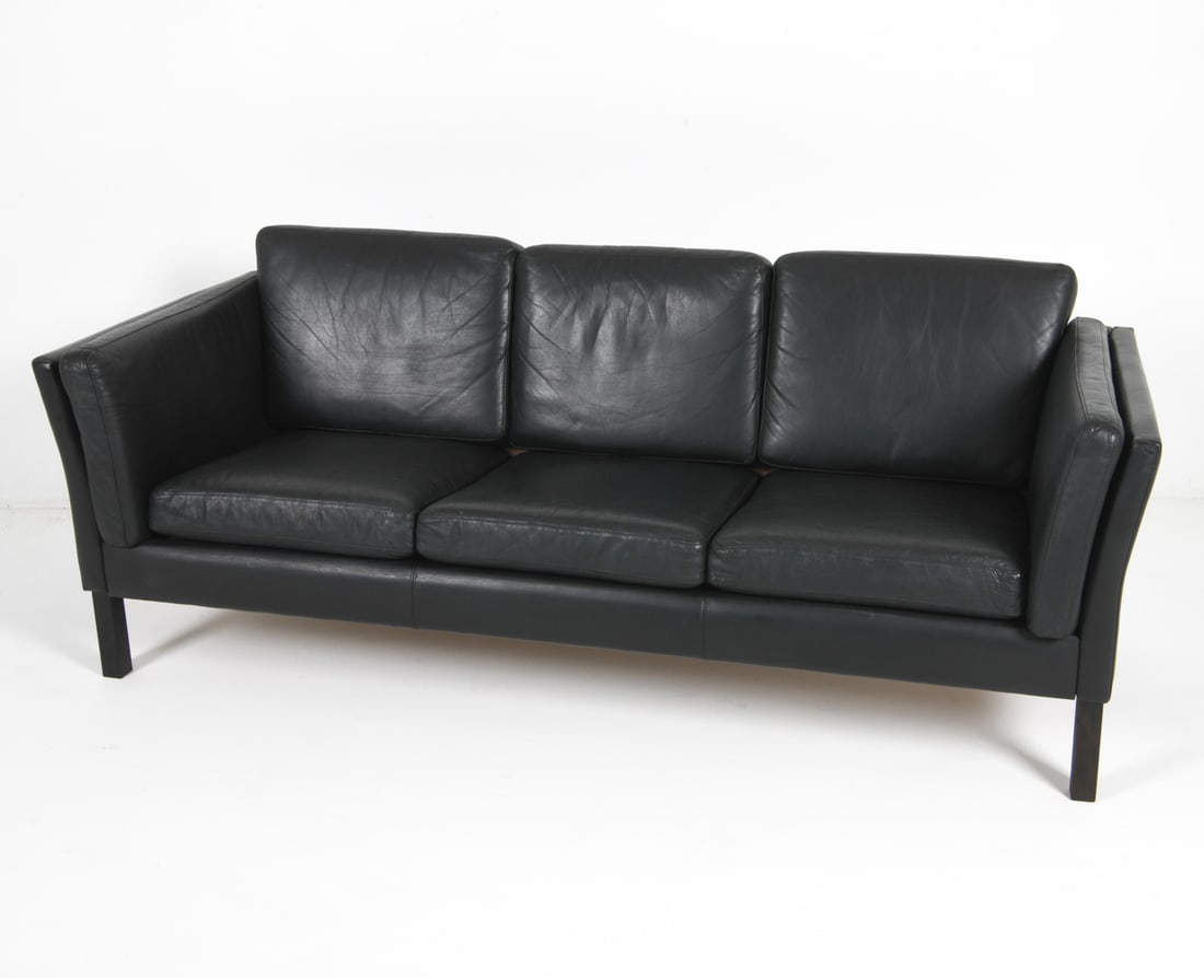 MOGENSEN STYLE DANISH LEATHER SOFA C. 1970S: In the manner of Borge Mogensen. Denmark. Circa 1970s. Black leather. Dimensions: H 25" x W 76" x D 30", SH 13.5" Condition: Moderate scuffs and marks to backside leather. Wear consistent with age and