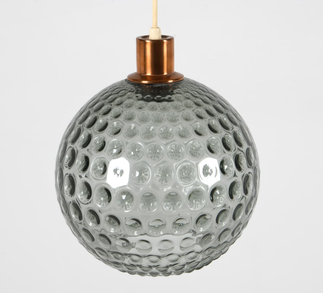 DANISH GLASS BALL PENDANT LIGHT C. 1960S: Textured glass ball shade with copper accent. Dimensions: Dia. 10.5". Condition: Wiring untested. Few scuffs to copper. Wear consistent with age and use.