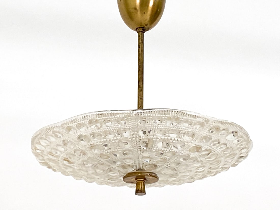 CARL FAGERLUND FOR ORREFORS PENDANT LIGHT C.1960S: Textured glass shade. Dimensions: H (to ceiling cap) 16" x Dia 19" Condition: Slight scattered scuffs to glass. Tarnishing to brass post and ceiling cap. Untested. Wear consistent with age and use.