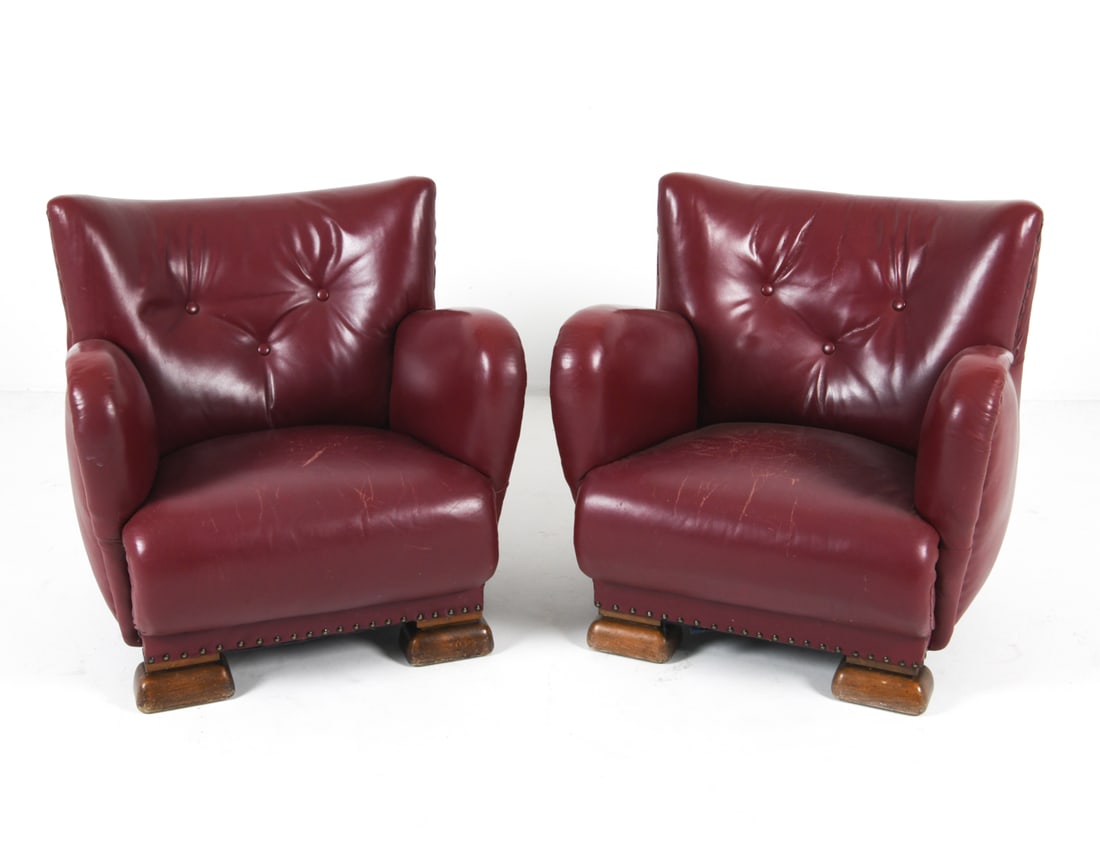 PAIR OF DANISH LEATHER LOUNGE CHAIRS 1960S: Red leather upholstery with oak legs. Dimensions: H 30" x W 30" x D 28" x SH 14.5". Condition: Some creasing and scratches to leather. Minor nicks and dings to feet. Wear consistent with age and use. 