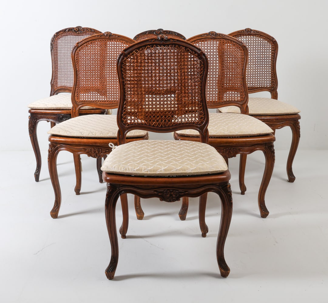 (6) LOUIS XV STYLE WALNUT & CANE SIDE CHAIRS: Carved detailing to seat backs and cabriole legs. Cane seat and backing. Dimensions: H 37" x W 19": x D 19" S.H. 17" Condition: Showing signs of wear including scratches and scuffs to wood finish. Few