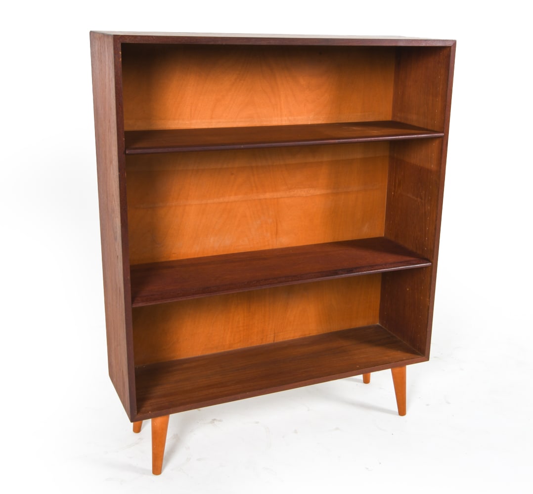 DANISH TEAK BOOKCASE C. 1960S: Adjustable shelves. Dimensions: H 50.25" x W 41" x D 12.25". Condition: Backboard is slightly warped. Few faint water spots. Wear consistent with age and use. JBN 063