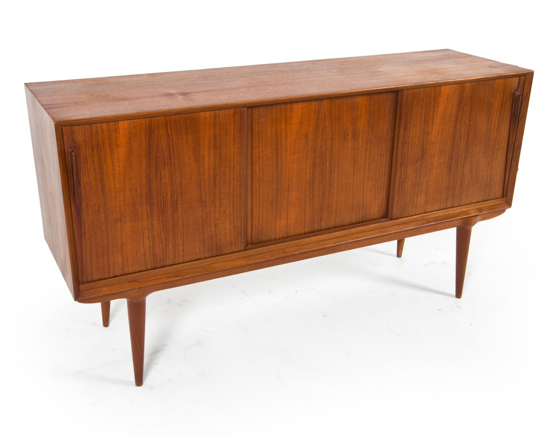 OMANN JUN MODEL 17 TEAK SIDEBOARD C. 1960S: Tag inside center cabinet. Adjustable shelves. Denmark, circa 1960s. Dimensions: H 34.25" x W 63.25" x D 18". Condition: Slight sun fading to top. Minor scratches inside. Wear consistent with age and