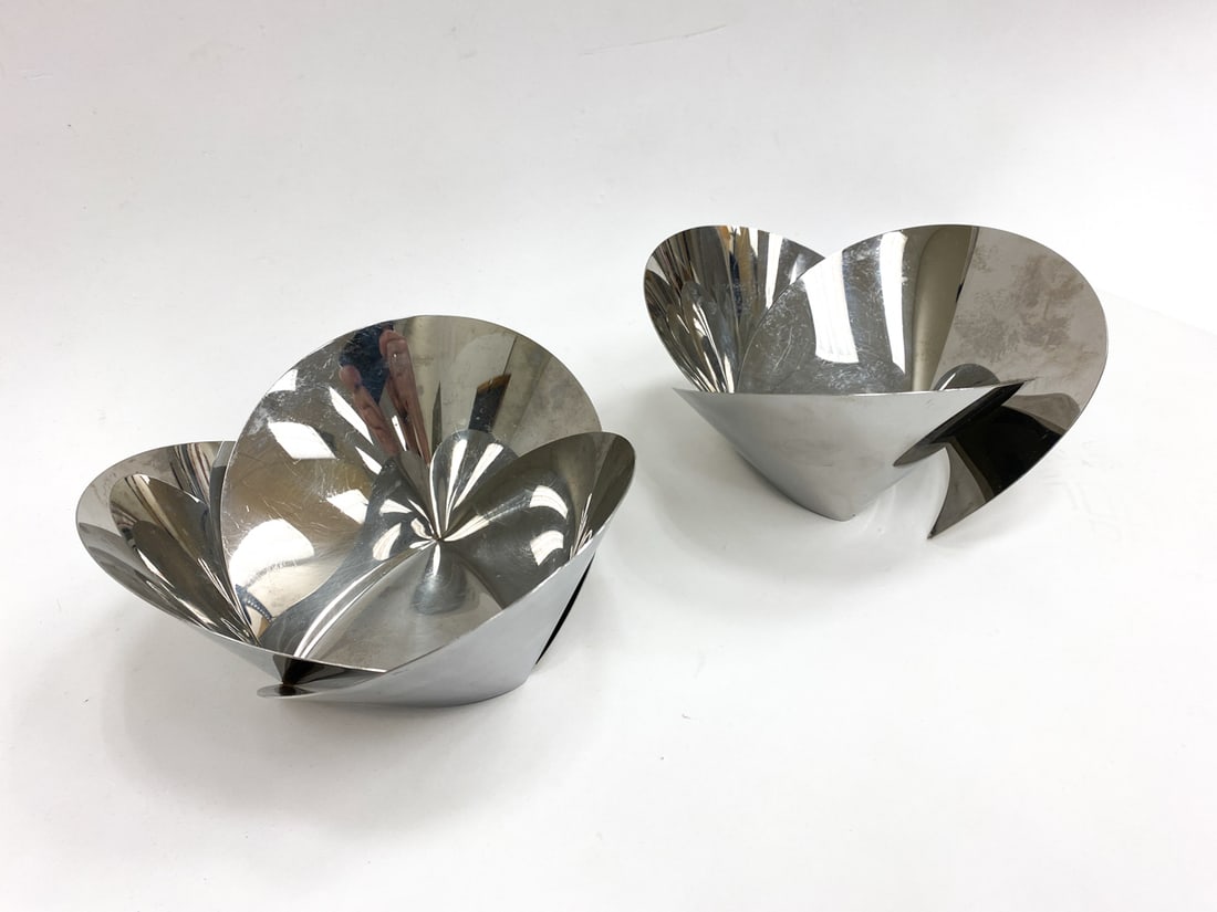 PAIR OF ALESSI ABI ALICE ABSTRACT BOWLS: Marked on undersides. Stainless steel abstract bowls. Provenance: From a Park Ave Manhattan apartment designed by David Kleinberg. Dimensions: H 4.25" x Dia 8.5" Condition: One bowl with a side detach