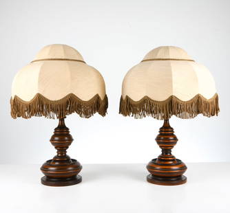 PAIR ART DECO BEECH TABLE LAMPS: With linen bell shades with hanging fringe. Dimensions: (With shades) H 30" x Dia 18" Condition: Minor residue to exterior to one. Minor surface scuffs. Cut wires. Untested. Presents well overall.