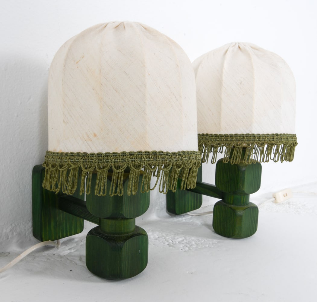 PAIR OF BIAB VARA SWEDISH PINE SCONCES 1960S: Painted green pine wall sconces. Tagged to wall brackets. Dimensions: H 13.25" x W 7.75" x D 8". Condition: Wiring untested, cords cut. Minor scuffs and rubs. Wear consistent with age and use.