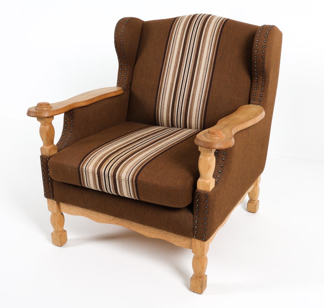 KJAERNULF STYLE DANISH OAK & WOOL LOUNGE CHAIR: Carved armrests and wool upholstery with brass tack edges. Dimensions: H 33.5" x W 31" x D 30". SH 17.5" Condition: Minor surface scuffs to oak frame. Presents well overall. GCE051