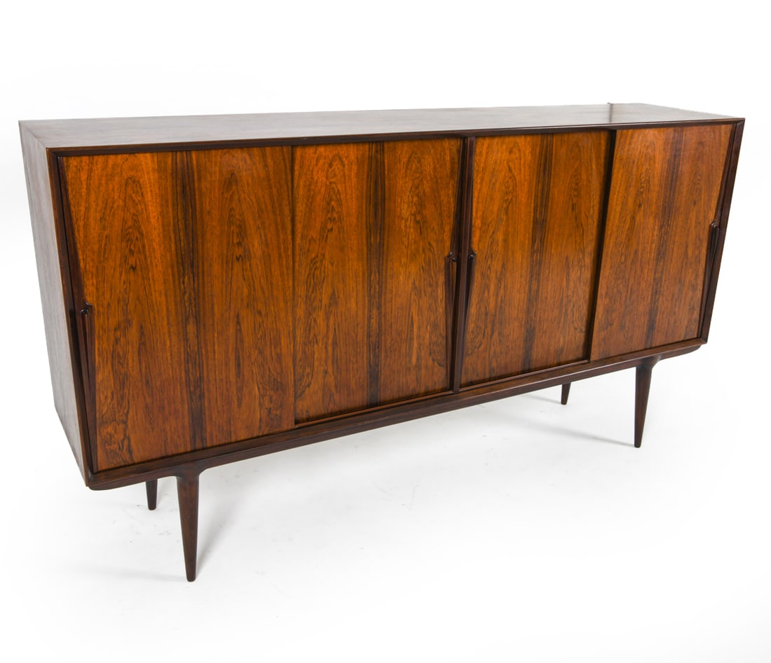 OMANN JUN MODEL 19 ROSEWOOD SIDEBOARD C. 1960S: Tag inside cabinet. Sits freely on base. Adjustable shelves. Dimensions: H 44" x W 80" x D 18". Condition: Minot scuffs and surface scratches. Wear consistent with age and use. E106