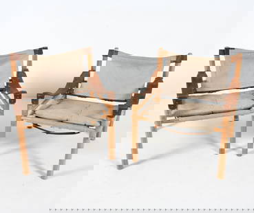 PAIR OF ARNE NORELL SIROCCO SAFARI CHAIRS: Oak frames with leather straps on arms and seat back. Tags to feet. Fabric upholstery. Sweden, circa 1960s. Dimensions: H