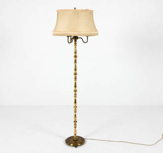 MID-CENTURY BRASS FLOOR LAMP C. 1950S: Neoclassical style with candle form lights and fringe to shade. Dimensions: H 63" x Dia. 19.25". Condition: Wiring untested, European plug. Scuffs and scratches to base. Wear consistent with age and u