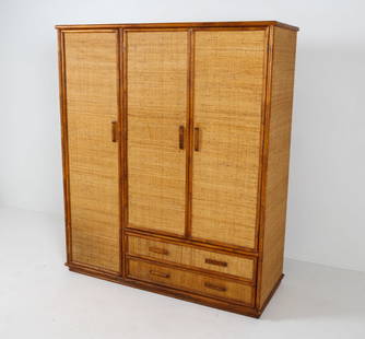 BAMBOO & CANE WARDROBE C. 1970S: Adjustable shelves. Bamboo wardrobe with cane paneling to all sides and door/drawer fronts. Dimensions: H 72" x W 60" x D 23". Condition: Some scuffs and scratches. Faint discolored spots to cane. Sli
