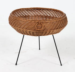 DUTCH WICKER TRIPOD MAGAZINE HOLDER C. 1950S: Tripod metal legs. Woven basket. Dimensions: H 18" x Dia 20.5" Condition: Slight scuffs to legs. Presents well overall. PN038