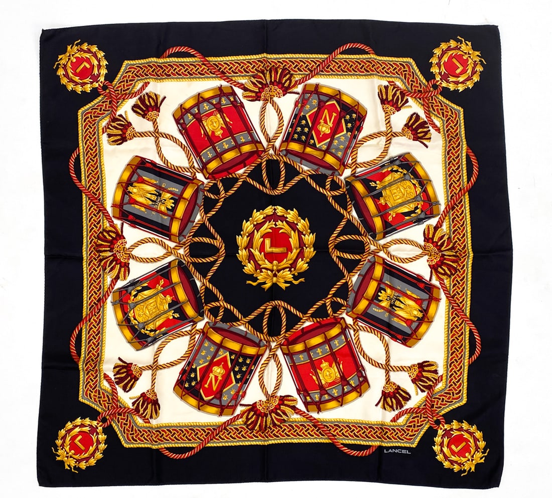 LANCEL DRUMS PATTERN SILK SCARF: Features tassels, drums, and ornate designs. Signed Lancel. Dimensions: L 34" x W 34" Condition: Creases from Being folded, no other issues to note.