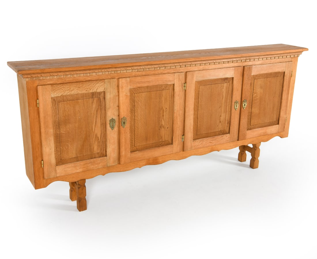 HENNING KJAERNULF STYLE DANISH OAK SIDEBOARD: Key included. From Carl Eriksens. Oak sideboard with carved detailing to cabinet doors and top rim. Uniquely narrow profile. Denmark, circa 1970s. Dimensions: H 35.75" x W 75" x D 10.75". Condition: F