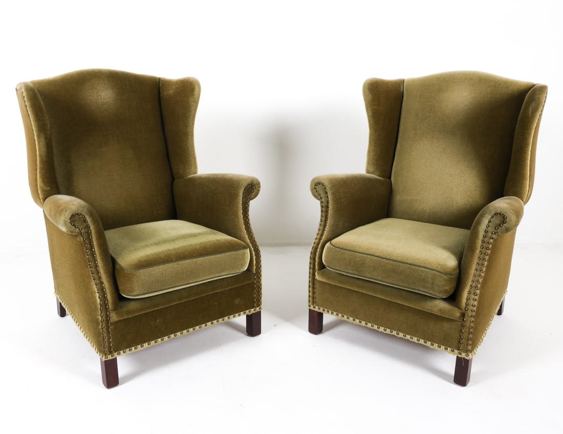PAIR DANISH MOHAIR WINGBACK CHAIRS C. 1960S: Green-tone mohair upholstery with tacked edges. Dimensions: H 39" x W 30.5" x D 27", SH 16.5" Condition: Rubbing and thinning to upholstery on armrests. Nicks and dings to legs. Presents well overall.