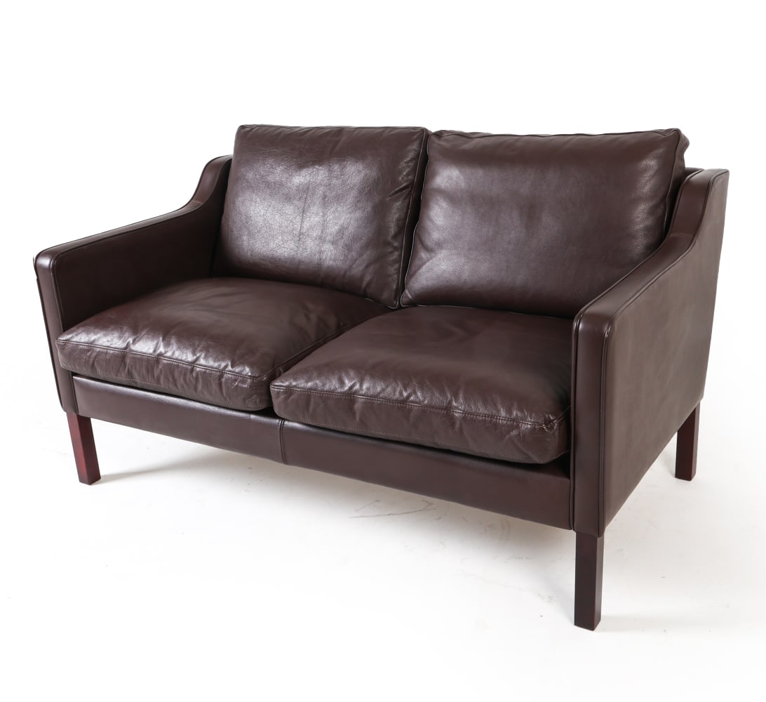 STOUBY DANISH LEATHER LOVESEAT SOFA: Circa 1970s. Brown leather. Stouby label to leg. Dimensions: H 26.76" x W 52" x D 30", SH 15" Condition: Minor scuffs to leather. Presents well overall. GCD078
