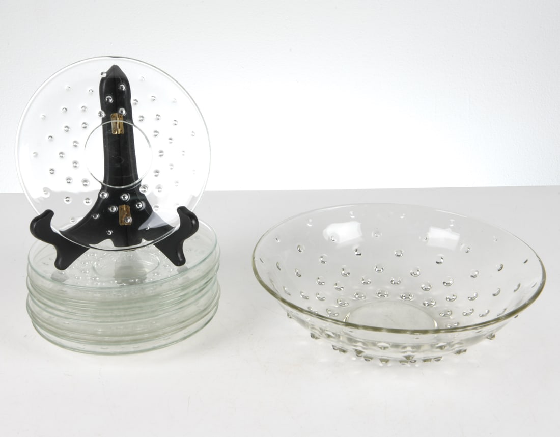 WILHELM WAGENFELD KUBUS GLASS GROUPING: Marked with 'XX' to undersides. (1) bowl and (11) plates, all stopped with exterior bubbles. Dimensions: (bowl) H 3.5" x Dia 12" Condition: Scattered scuffs and scratches to glass. Wear consistent wit