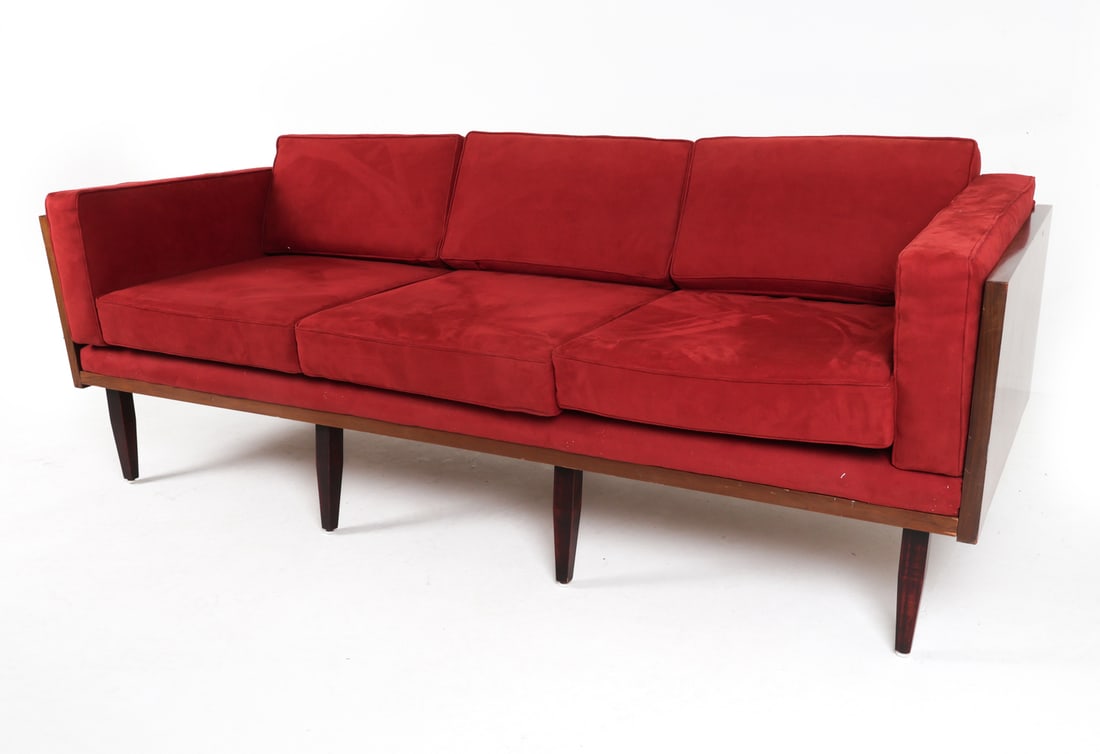 MID-CENTURY KOMFORT DANISH TEAK & RED VELVET SOFA: Red velvet upholstery with teak veneer to sides. Tagged underneath. Dimensions: H 28" x W 83" x D 32" x SH 19". Condition: Minor scuffs and dings to wood. Slight fading to velvet. Wear consistent with