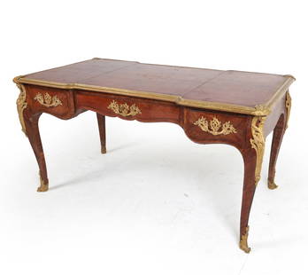 ANTIQUE FRENCH LOUIS XV STYLE ORMOLU DESK: Includes (1) Key. With brass ormolu to legs and tabletop. Tooled leather top. Dimensions: H 30" x W 59" x D 32" Condition: Moderate scuffs and nicks to leather, with scattered surface blemishes. Ormol