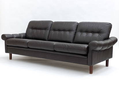 MID-CENTURY DANISH TUFTED LEATHER SOFA: Dark brown leather upholstered sofa with tufted buttons. Vertical piping detail to armrest. Apparently unmarked. Dimensions: H 25" x W 78" x D 31" x SH 15" Condition: Wear consistent with age. Faint t