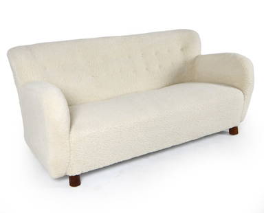 FRITZ HANSEN STYLE DANISH LAMBSWOOL SOFA: In the style of Fritz Hansen. White-tone lambs wool upholstery. Dimensions; H 29" x W 68" x D 30", Sh 15" Condition: Scattered nicks and scuffs to legs. Presents well overall.