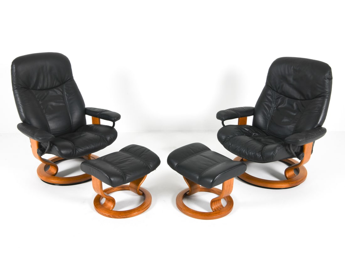 EKORNES STRESSLESS LOUNGE CHAIRS & OTTOMANS: Denmark, Circa 1970s. Black-tone leather upholstery. Recliner chairs. Dimensions: H 37" x W 33" x D 26", SH 18" Ottoman: H 15" x W 18" x D 14" Condition: Light nicks and scuffs to wood frames. Present