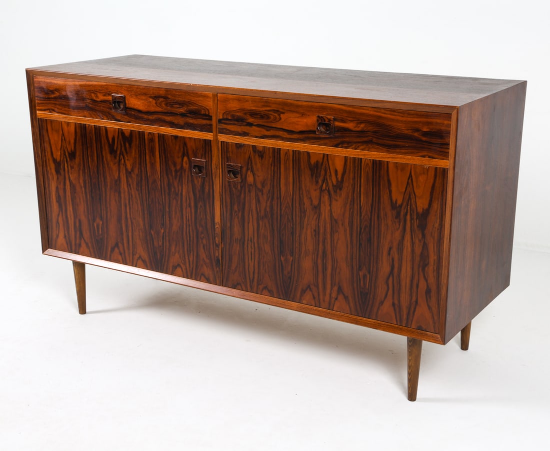MID-CENTURY DANISH ROSEWOOD CREDENZA C. 1960S: With adjustable shelves. Dimensions: H 30.75" x W 53.25" x D 19.75" Condition: Light nicks and surface scuffs. Wear consistent with age and use. Presents well overall.