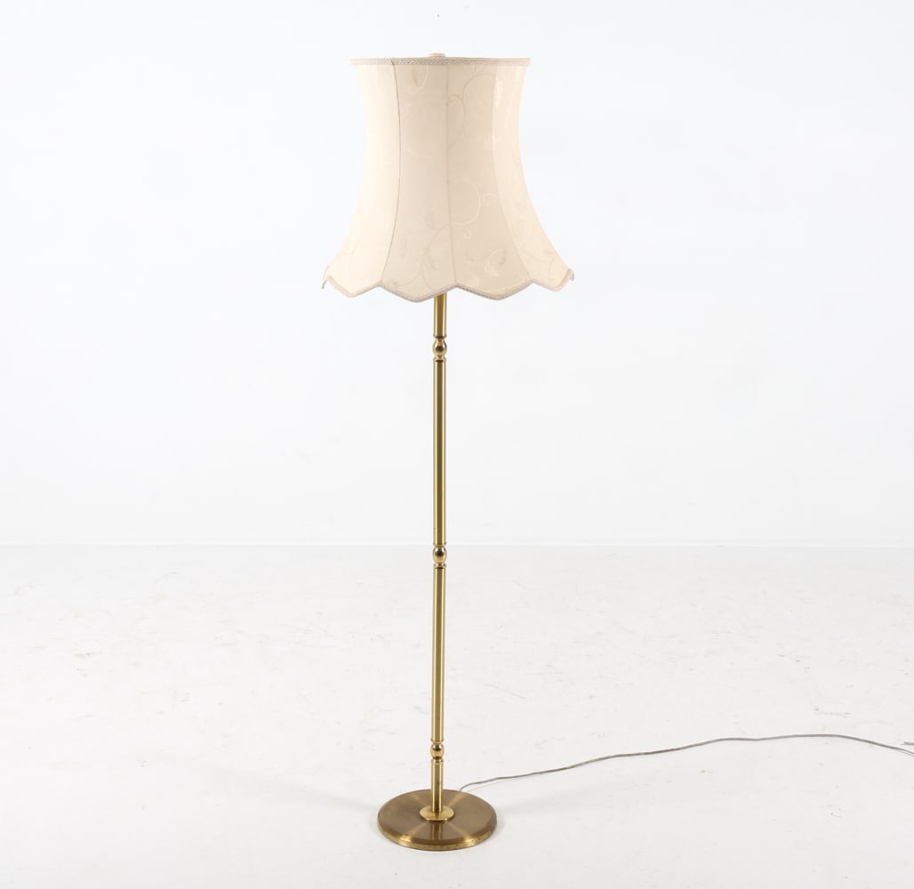 MID-CENTURY SCANDINAVIAN BRASS FLOOR LAMP C. 1960S: Brass-tone metal post with bell shaped shade. Dimensions: (with shade) 61" x Dia 19" Condition: Scattered marks and scuffs to center post. Slight indentations to base. Cut wire, Untested. Wear consist