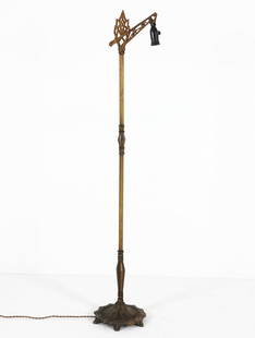 ART DECO BRASS BRIDGE FLOOR LAMP C. 1940S: Brass and brass-tone brushed metal throughout. With ornate design to bridge. Etching to center post and repousse to base. Dimensions: H 59" x Dia 11" Condition: Moderate tarnishing and patina to meal.