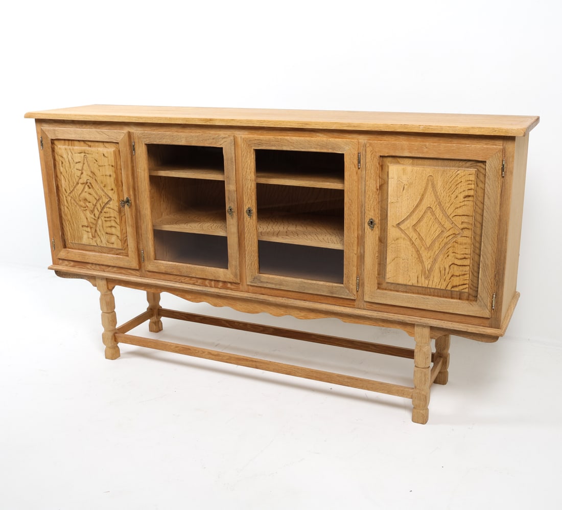 HENNING KJAERNULF STYLE DANISH OAK SIDEBOARD 1970S: Key included. Glass panel cabinet doors. Adjustable shelves. Carved diamond decoration to side cabinet doors. Denmark, circa 1970s. Dimensions: H 43.5" x W 80" x D 18". Condition: Minor scuffs and scr