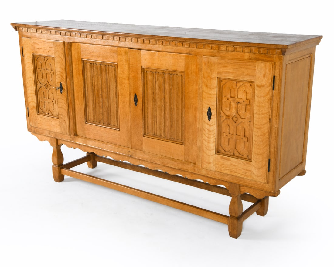 KJAERNULF STYLE DANISH OAK SIDEBOARD C. 1970S: Key included. Carved decoration to cabinet doors. Adjustable shelves. Dimensions: H 45.5" x W 82" x D 19".Condition: Minor scuffs and dings, great presentation overall. DDE C