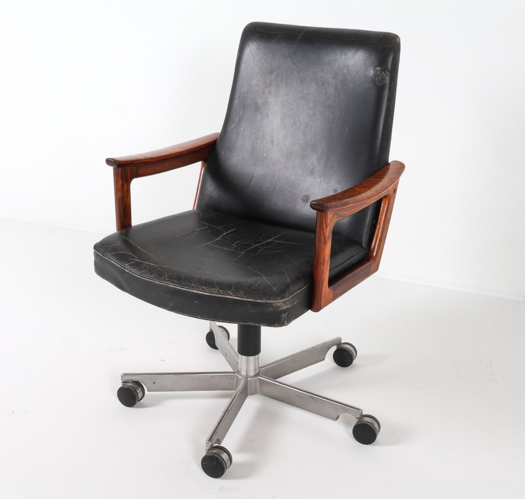 ARNE VODDER LEATHER & ROSEWOOD OFFICE CHAIR: With rosewood armrests on swivel base. Dimensions: H 38.75" x W 25.5" x D 26.5" Conditions: Wear consistent with age and use, previous repair to leather on backrest, cracking present to seat and backr