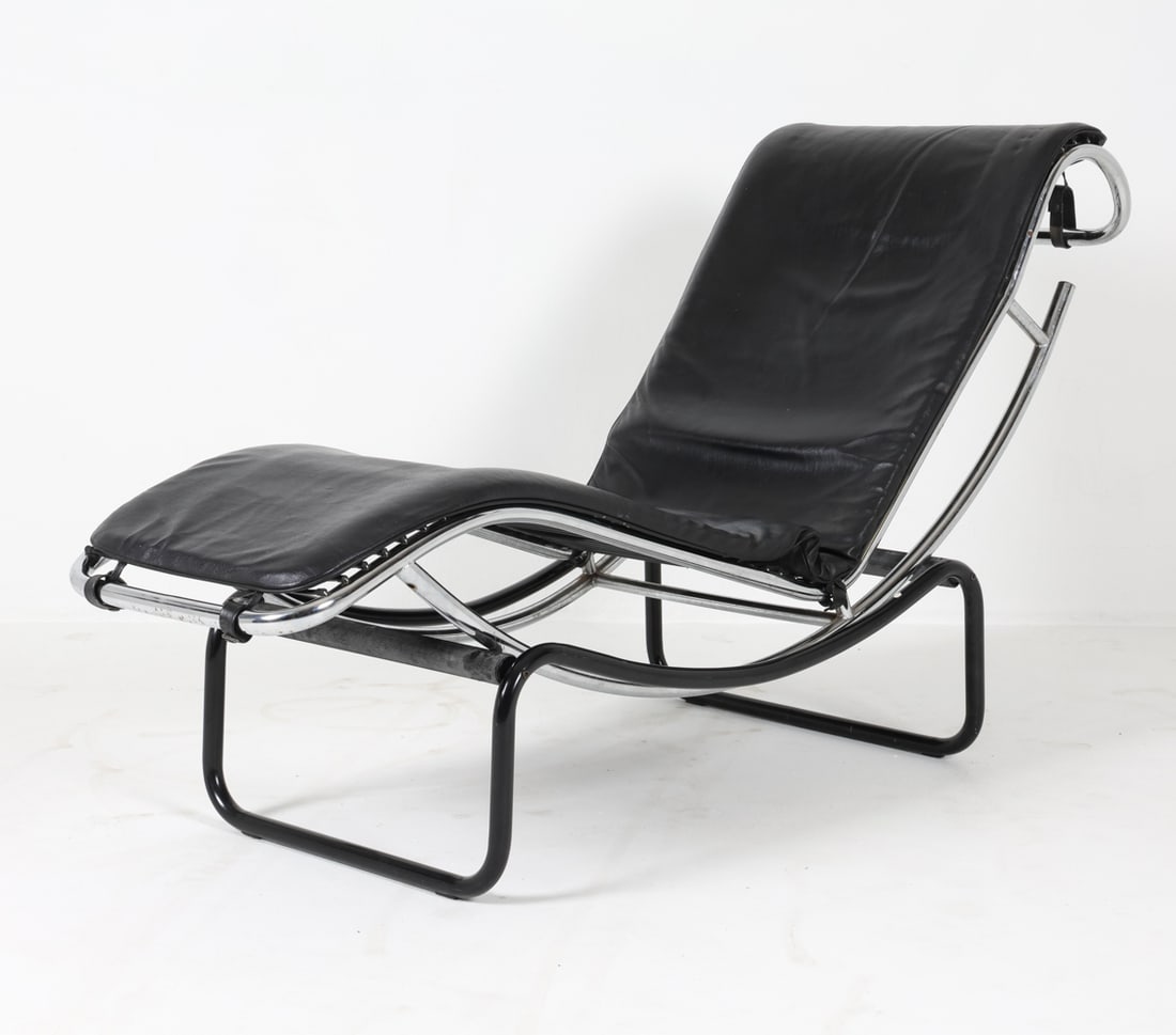 LE CORBUSIER STYLE LEATHER CHAISE LOUNGE CHAIR: Chaise lounge in the style of the LC4 lounge chair from Le Corbusier. Upholstered in black leather. Chromed tubular steel frames. Dimension: H 33.5" x W 22.75" x D 63" x Sh 18.25". Conditions: Minor s