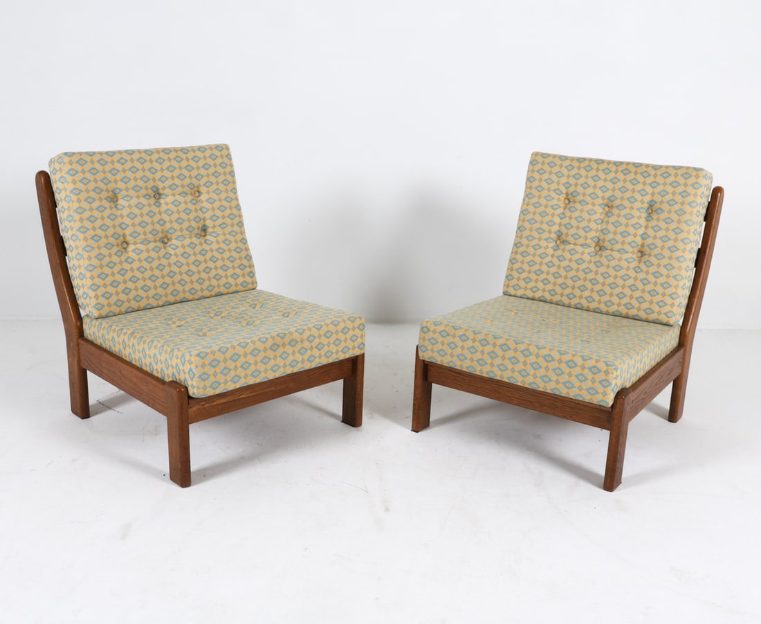 PAIR OF DANISH OAK LOUNGE CHAIRS 1970S: Pair of lounge chairs in the style of Carl Straub. Oak frames with patterned fabric cushions. Denmark, circa 1970s. Dimensions: H 30" x W 26" x D 27" x SH 13.5". Condition: Minor scuffs and dings to f