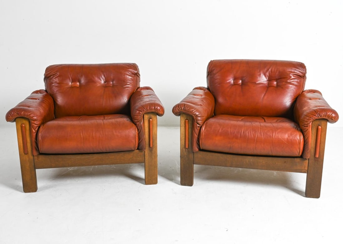 PAIR OF LOUNGE CHAIRS IN MANNER OF PERCIVAL LAFER: This captivating pair of Scandinavian oak and leather armchairs are in a design inspired by the renowned Brazilian designer, Percival Lafer. Crafted in the 1970s, these chairs capture the essence of L
