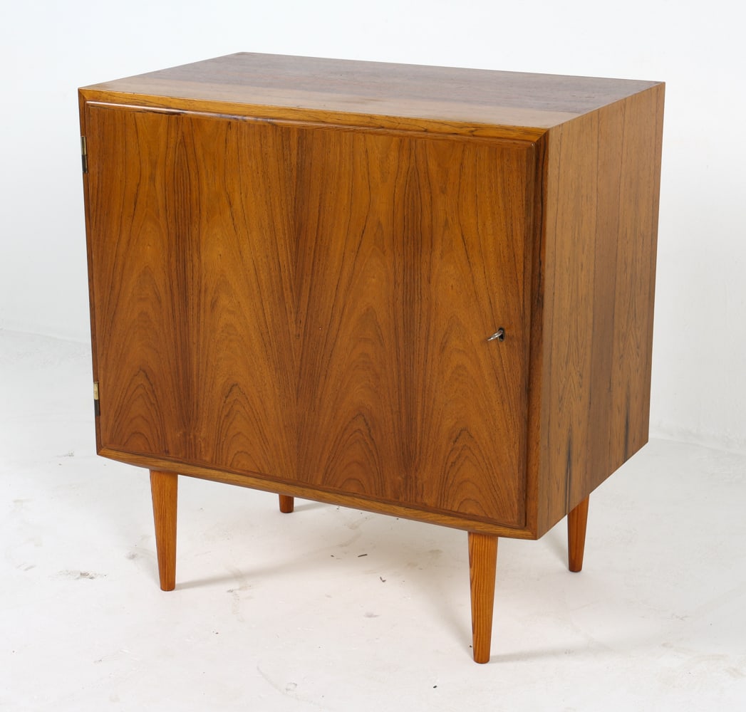 HUNDEVAD DANISH ROSEWOOD CABINET C. 1960S: Stamped to backside. includes (1) Key. Adjustable shelves. Dimensions: H 29.5" x W 27.75" x D 17.5" Condition: Sun fading to sides. Scattered nicks, and scuffs. Wear consistent with age and use.