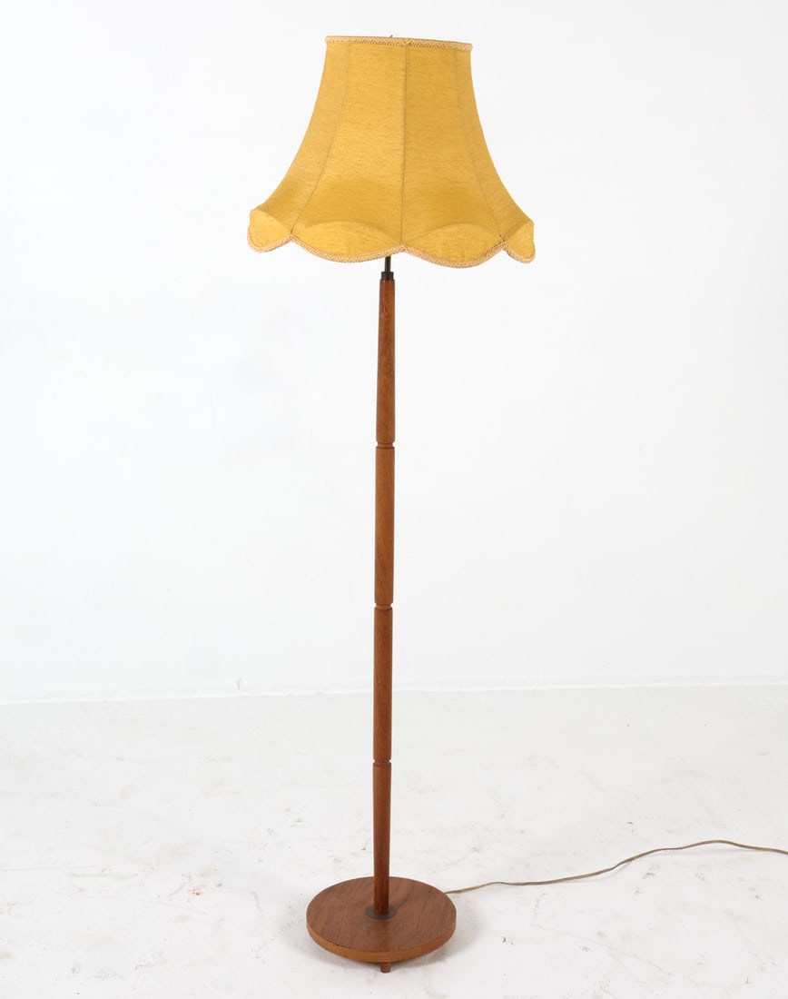 SCANDINAVIAN TEAK FLOOR LAMP C. 1960S: Turned teak floor lamp. Yellow fabric shade. Scandinavian, circa 1960s. Dimensions: H 60" x Dia. 18". Condition: Wiring untested, European plug. Few oxidized spots to brass. Wear consistent with age a