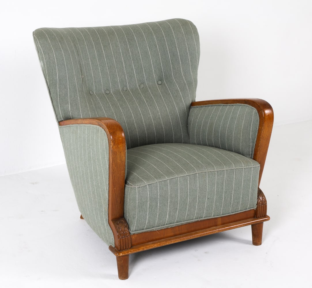 ART DECO SCANDINAVIAN WOOL LOUNGE CHAIR 1940S: Lounge chair with oak arms and feet. Carved decoration to front feet. Striped wool upholstery. Dimensions: H 34" x W 27.5" x D 28" x SH 14.5". Condition: Few scratches and dings to wood. Wear consiste
