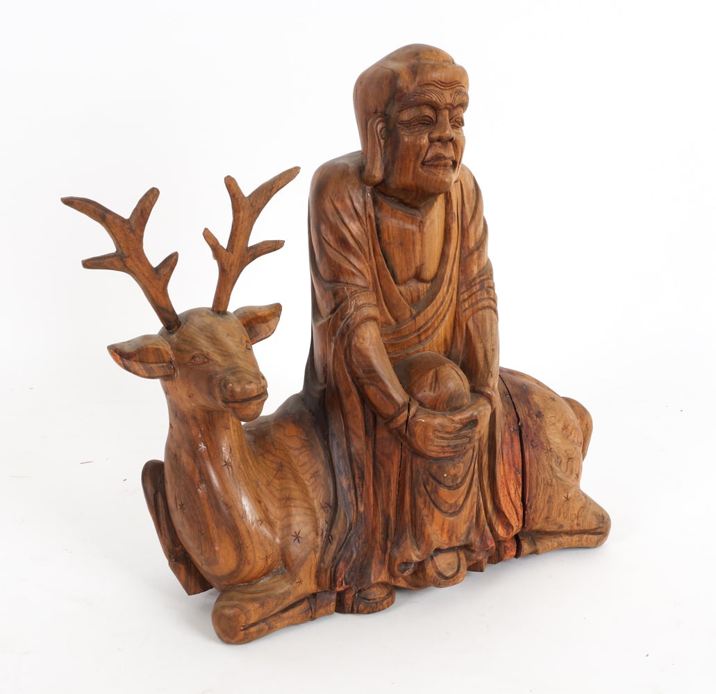 VINTAGE CARVED DEER SITTING LOHAN SCULPTURE: Carved depiction of Buddhist fugure known as Deer-Sitting Lohan: Pindola the Bharadvaja. Dimensions: H 15" x W 15.5" x D 5.5". Condition: Some stress splits to wood. Minor scuffs and rubs. Loose antle