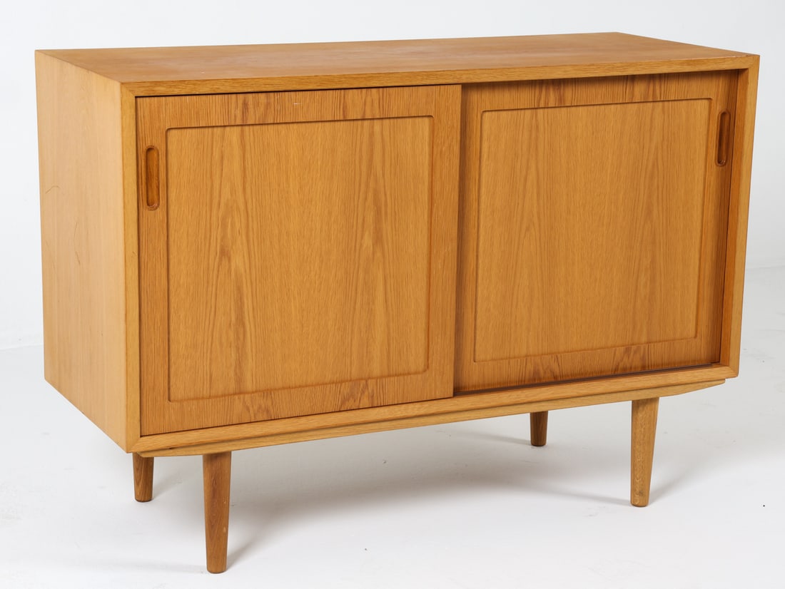 POUL HUNDEVAD DANISH OAK SIDEBOARD C. 1960S: For HU Mobler. Tagged to top back corner. Adjustable shelves. Denmark, circa 1960s. Dimensions: H 30" x W 42.5" x D 17". Conditions: Minor dings and scuffs to top and sides. Wear consistent with age a