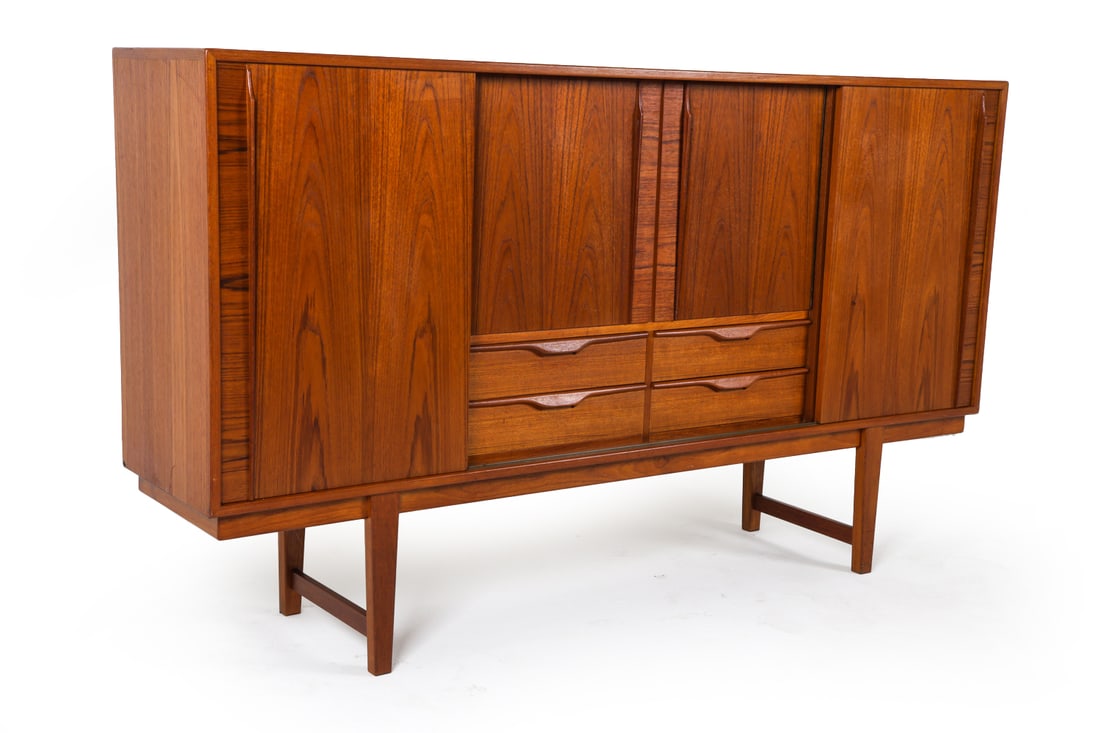 OMANN JUN STYLE DANISH TEAK HIGHBOARD C. 1960S: Teak high board with adjustable shelves and drawers. Dry bar to center cabinet with frosted glass backing. Denmark, circa 1960s. Dimensions: H 44.5" x W 76.25" x D 17". Conditions: Light surface wear