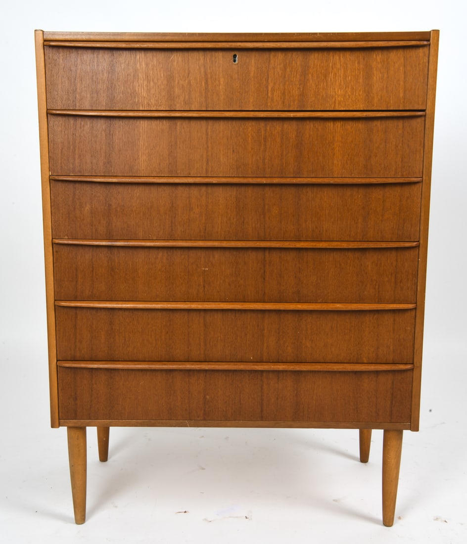 MID-CENTURY DANISH TEAK CHEST OF DRAWERS C. 1960S: Features a 6-drawer chest of drawers. Unmarked. Denmark, circa 1960s. Dimensions: H 41" x W 30.5" x D 15.5" Condition: Lacking key and escuchen. Small losses of veneer at edges. Some sun fading. Light