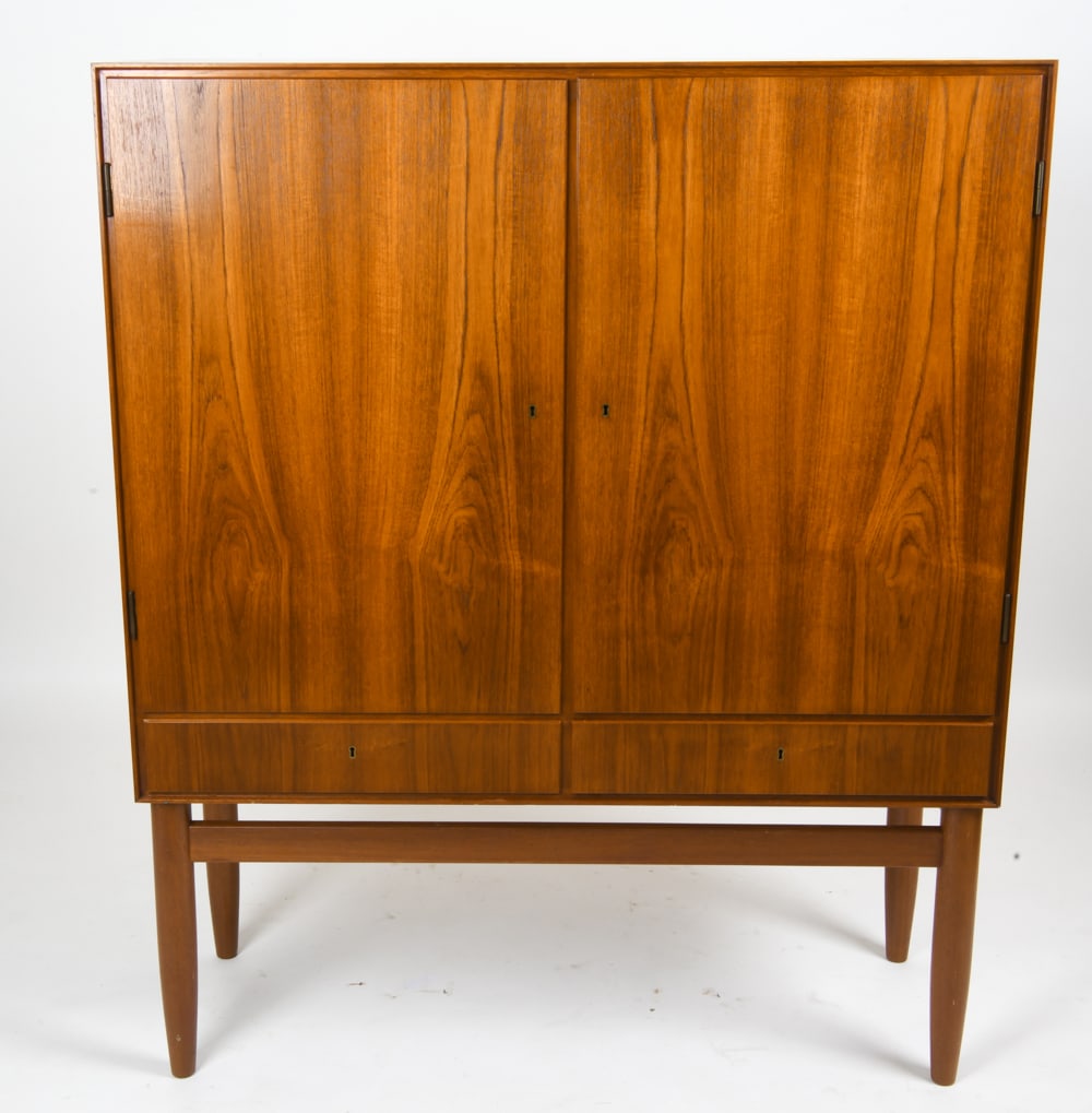 ARNE VODDER STYLE TEAK HIGHBOARD CABINET C. 1960S: Cabinet with two interior spaces, each with 2 shelves, and two small drawers underneath in the Arne Vodder style. Includes one key. Apparently unmarked. Circa 1960s. Dimensions: H 57.25" x W 47.25" x