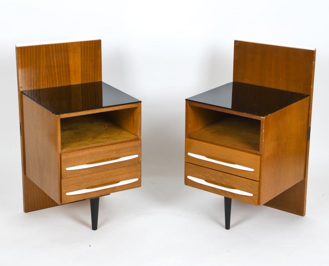 UP ZAVODY POLISH BEECHWOOD NIGHTSTANDS C. 1960S: Set of two beechwood nightstands by Mojmir Pozar for UP Zavody, featuring two drawers each, white-painted handles and a shelf. Appears to have been connected to a headboard at a previous time. Poland,