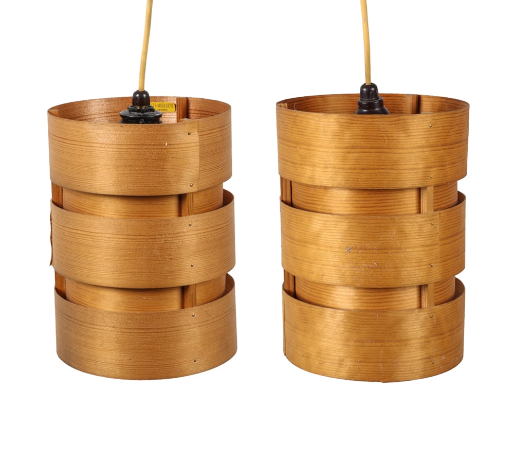 PAIR HANS-AGNE JAKOBSSON PINE PENDANT LIGHTS: Pine veneer pendant lights. Tagged "AB ELLYSETT MARKARYD" to the interior. Sweden, circa 1970s. Dimensions: H 8.75" x Dia. 6.5". Condition: Wiring untested. Wear consistent with age and use. Minor sep