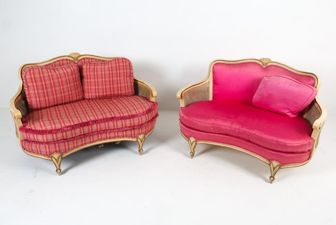 PAIR OF FRENCH LOUIS XV STYLE SETTEES: Pair of settee sofas in the style of Louis XV with pink satin upholstery. Caning to sides. Mid 20th century. Dimensions: H 32" x W 49" x D 34" x SH 16". Condition: Soiling and fading to fabric/cushion