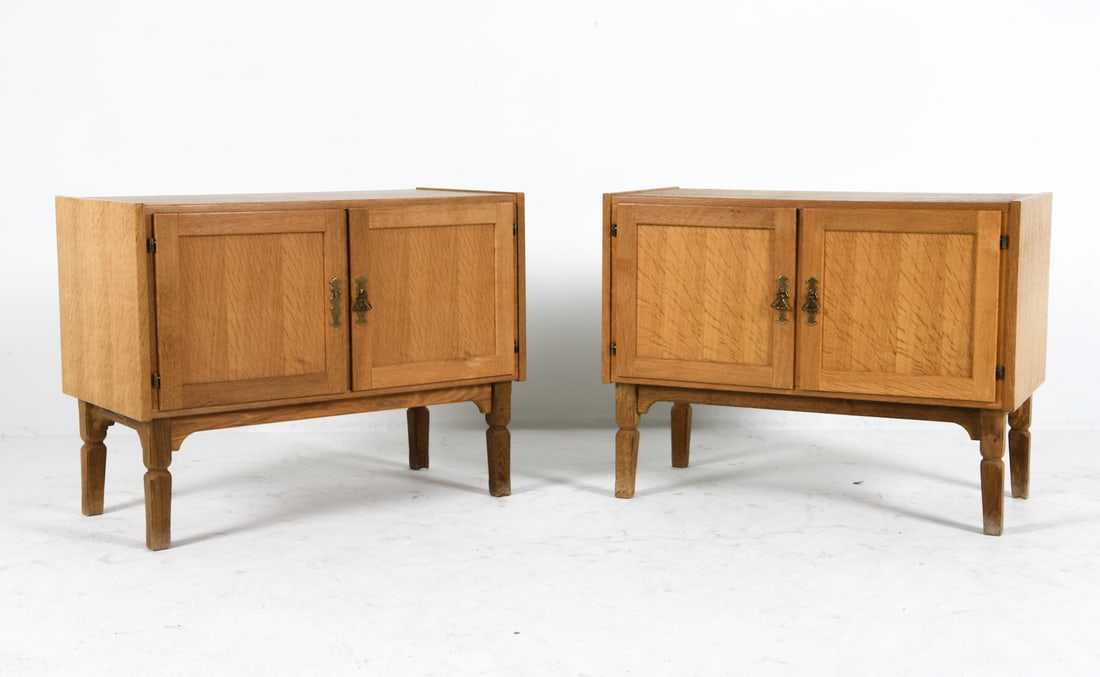 ATTR. HENNING KJERNULF DANISH OAK CABINETS 1970S: Oak cabinets with turned legs. Denmark, circa 1970s. Dimensions: H 25.5" x W 33" x D 17". Condition: Minor scratches. One missing brass pull. Wear consistent with age and use.