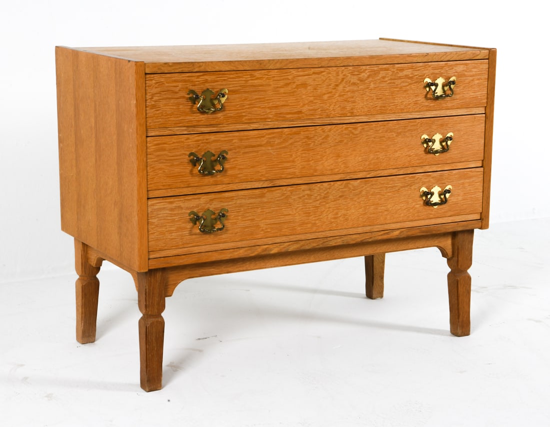 ATTR. HENNING KJARENULF DANISH OAK CHEST C. 1970S: Oak chest of drawers with brass drawer pulls. Denmark, circa 1970s. Dimensions: H 25.5" x W 33" x D 17". Condition: Some slight sun fading to top. Minor scuffs and scratches. Wear consistent with age 