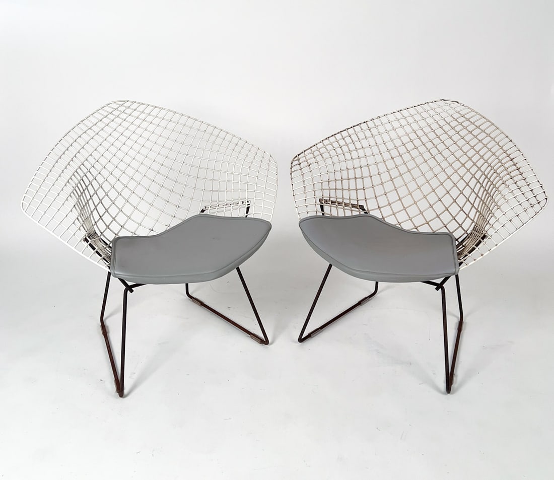 PAIR OF KNOLL HARRY BERTOIA DIAMOND LOUNGE CHAIR: Welded steel rod frames with white and oxidized finishes, each with snap-on seat pad. Apparently unmarked. Circa 1960s. Dimensions: (Larger) H 27" x W 44" x D 32", SH 16" (Smaller) H 30.5" x W 33.5" x